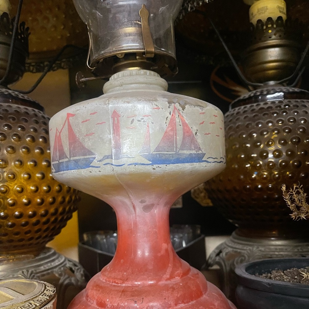 Vintage oil lantern with nautical scenery.